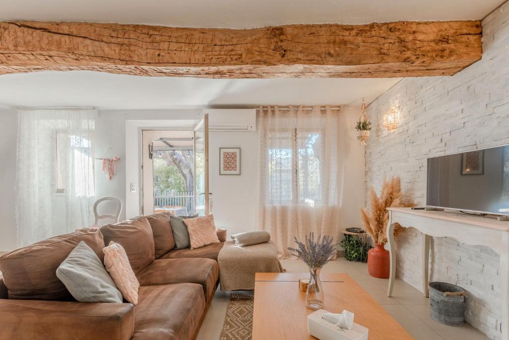 a living room with a brown couch and a fireplace at Maison Sainte Maxime in Le Plan