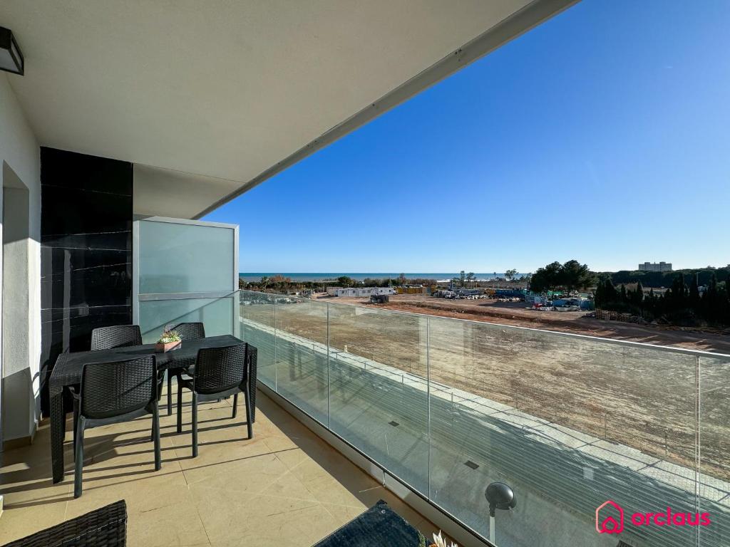 ein Balkon mit Tisch und Stühlen und einem großen Fenster in der Unterkunft Brisa Azul in Cabanes