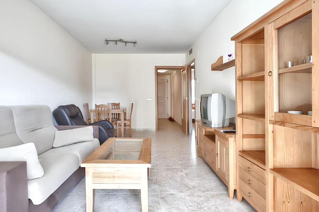 a living room with a couch and a table at Comfortable apartment in Platja de la Pineda 70 m² with pool in La Pineda