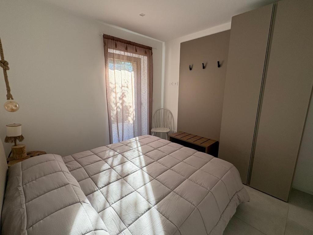 a white bedroom with a bed and a window at Seaside Resort in Trieste