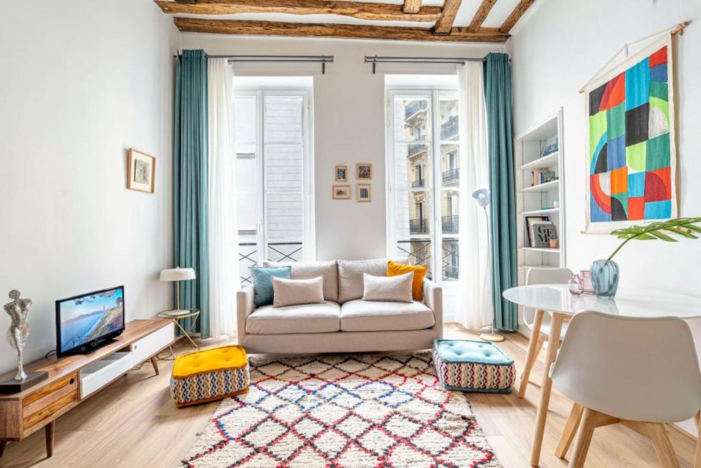 un salon avec un canapé et une table dans l'établissement Stylish Parisian Flat in the Marais - SAINT-PAUL, à Paris