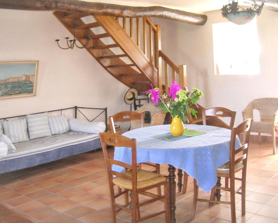 une salle à manger avec une table avec un vase de fleurs dans l'établissement Maison chaleureuse avec grand jardin à Erdeven, à Erdeven