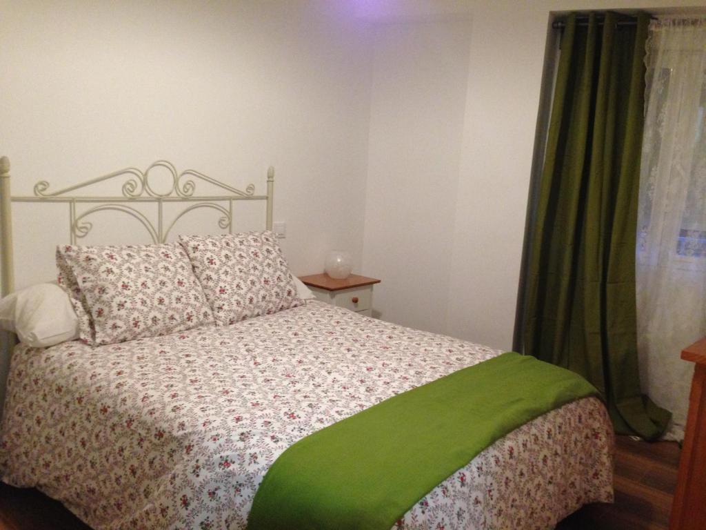 1 dormitorio con 1 cama con manta verde en Apartamento En La Sierra II, en Arenas de San Pedro