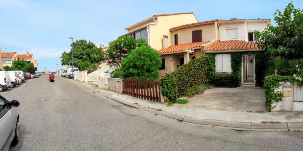 a street with houses and cars parked on the side of the road at Maison familiale à Sainte-Marie in Sainte-Marie-Plage