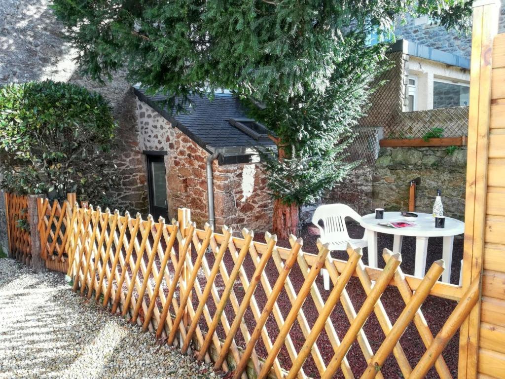 a wooden fence with a table in a backyard at Charmante maison avec cheminée à Saint-Jacut-de-la-Mer in Saint-Jacut-de-la-Mer