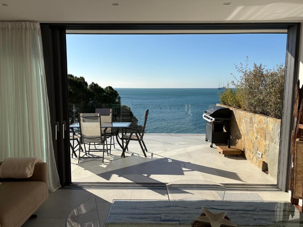 a patio with a view of the ocean through a sliding glass door at Seaside Resort in Trieste