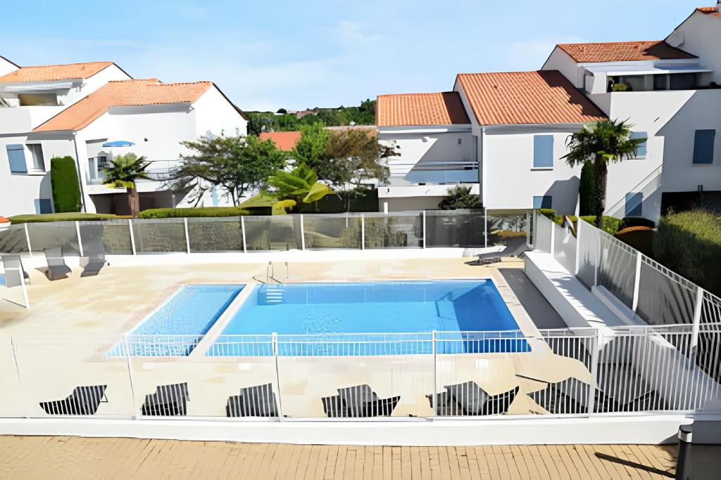 a view of a swimming pool in a villa with houses at Maison charmante à Vaux-sur-Mer avec piscine partagée in Vaux-sur-Mer