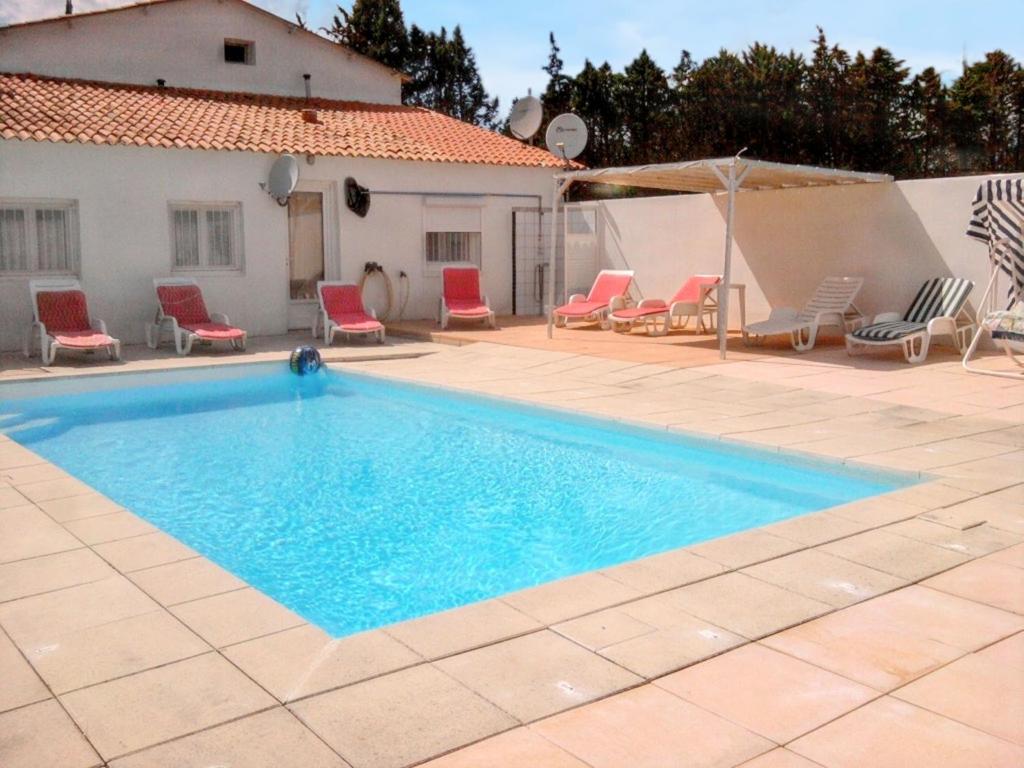 une piscine avec des chaises et une maison dans l'établissement Villa charmante à Meynes avec piscine privée, à Meynes
