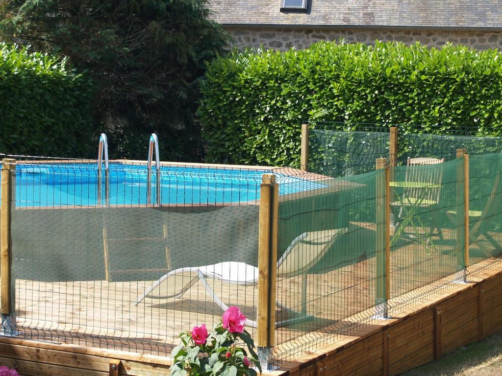 un chien dans une cage à côté d'une piscine dans l'établissement Large Welcoming House of 15 people, à Melrand