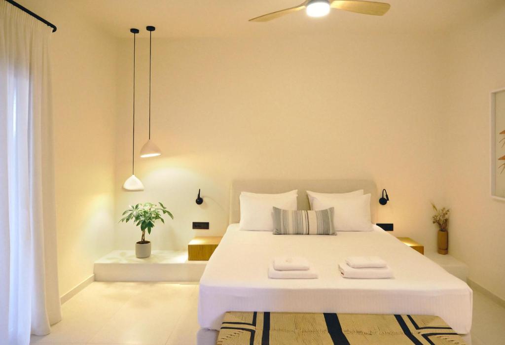 een slaapkamer met een wit bed met twee handdoeken erop bij Agave Donousa Suites in Donoussa