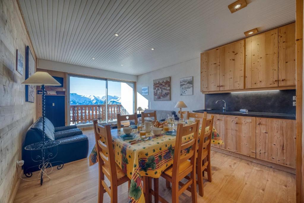 une salle à manger avec une table et des chaises et une cuisine dans l'établissement #AH9 At the bottom of the ski slopes, à L'Alpe-d'Huez