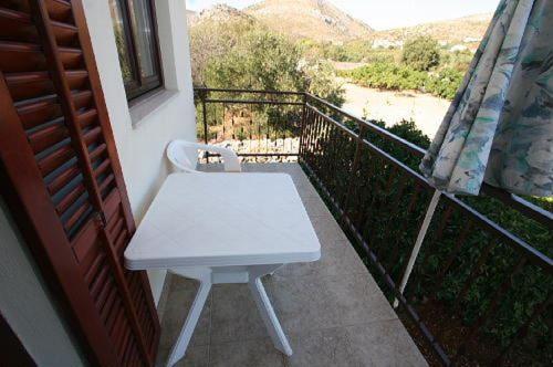 a white bench on a balcony with a view at Apartments Gordana in Trogir