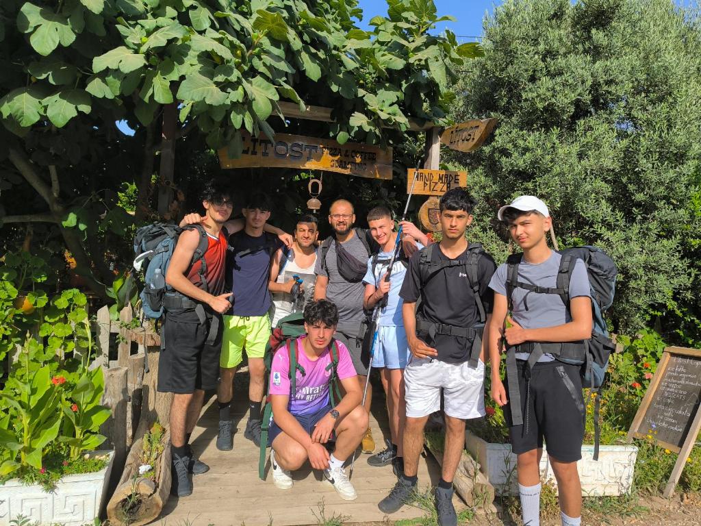 a group of people standing in front of a sign at Litost Cafe in Adrasan