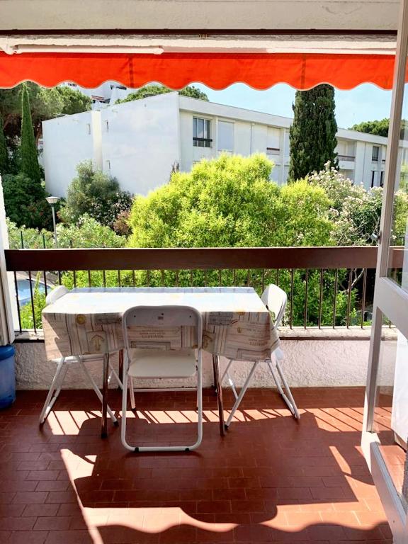 d'une table blanche et de deux chaises sur un balcon. dans l'établissement Studio charmant & lumineux à La Grande-Motte - 22 m² + Balcon, à La Grande Motte