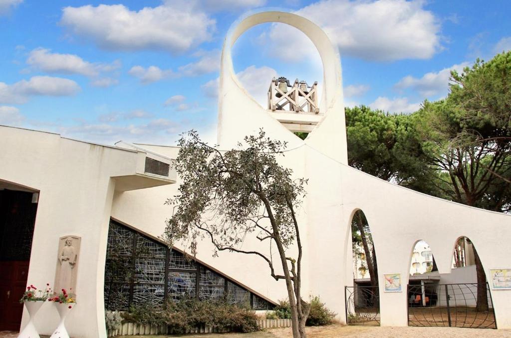 ein weißes Gebäude mit Seitenbogen in der Unterkunft Studio charmant & lumineux à La Grande-Motte - 22 m² + Balcon in La Grande-Motte