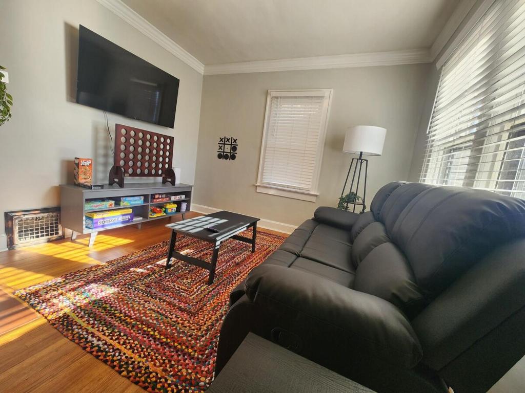 Una sala de estar con un sofá y un televisor de pantalla plana. en Katherine's Cozy Bungalow, en Terre Haute