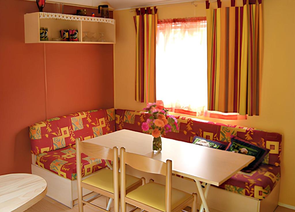 ein Wohnzimmer mit Tisch und Couch in der Unterkunft Charmant Bungalow à Juncalas avec Terrasse et Vue Montagne in Juncalas