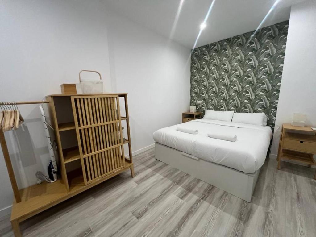 a small bedroom with a bed and a mirror at Loft San Carlos in Alicante