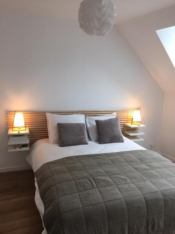 une chambre avec un grand lit avec deux lampes dans l'établissement Appt au pied de la cathédrale avec parking gratuit, à Amiens