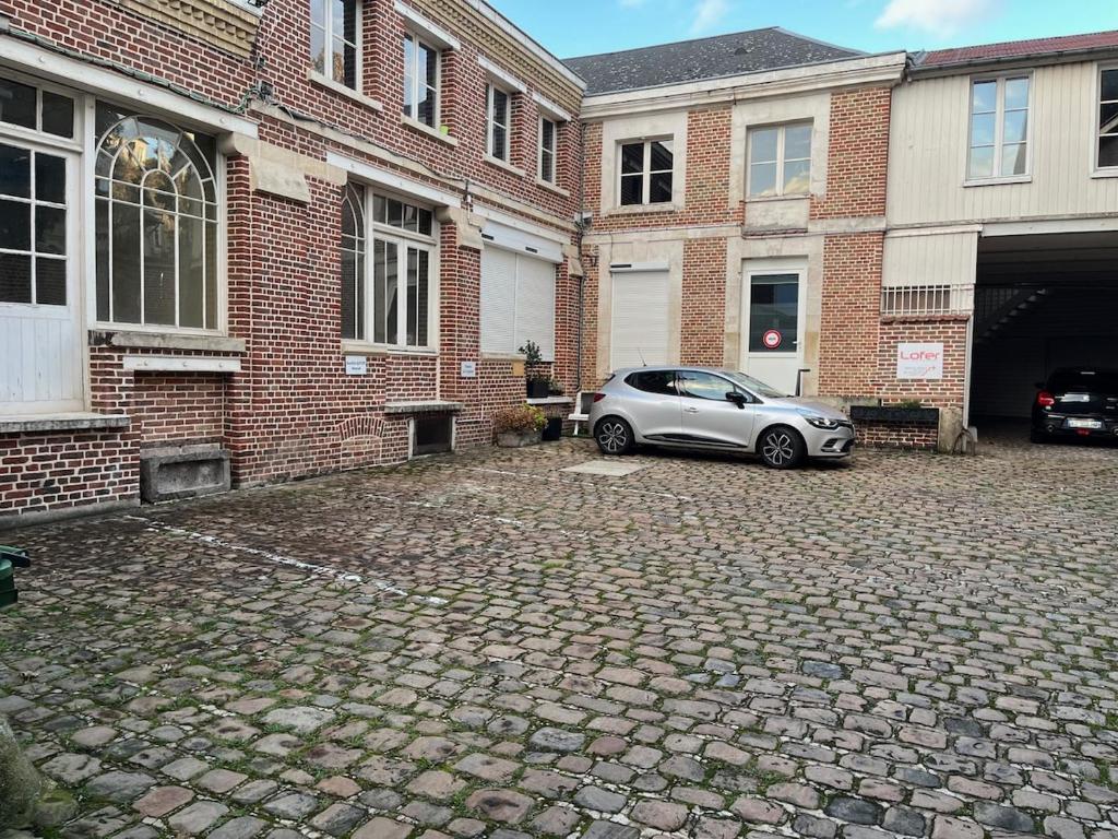 a car parked in front of a brick building at Appt au pied de la cathédrale avec parking gratuit in Amiens