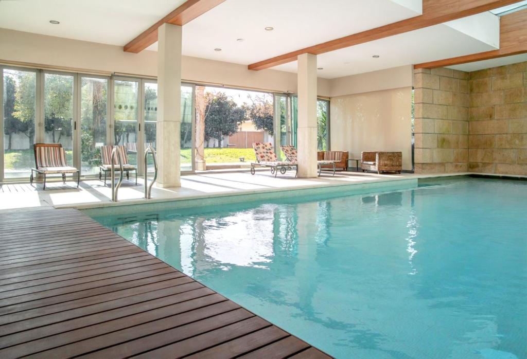a large swimming pool in a house with a porch at Spacious villa in Santo Tirso with private pool 850 m² and jacuzzi in Santo Tirso