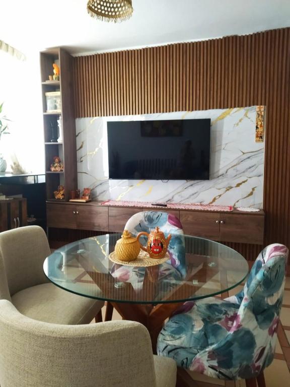 a glass table in a living room with two chairs at Alojamiento & Místico in Ayacucho