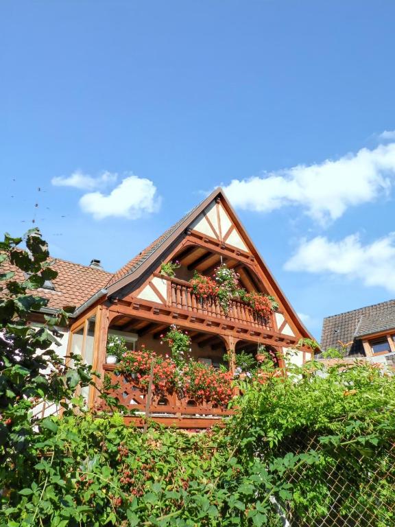 une maison avec un balcon fleuri dans l'établissement Maison charmante avec vue sur la montagne à Triembach-au-Val, à Triembach-au-Val