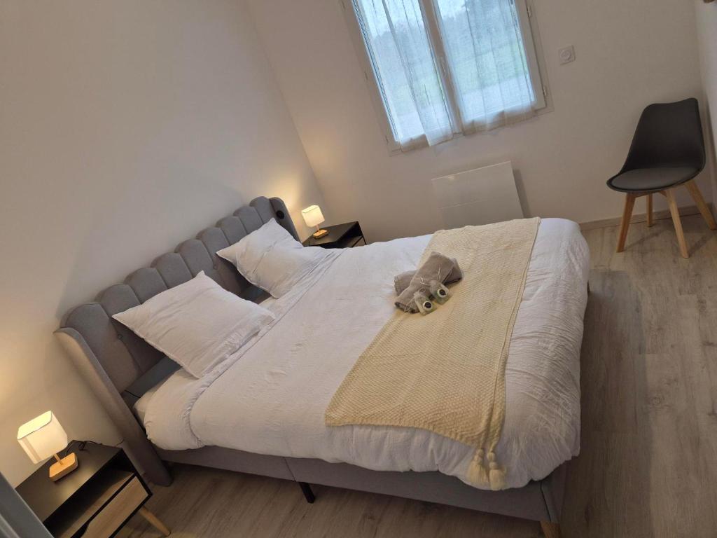 a bed with a stuffed animal on top of it at Belle Maison 3 Chambres 9 Personnes Grayan et L'Hopital in Grayan-et-lʼHôpital
