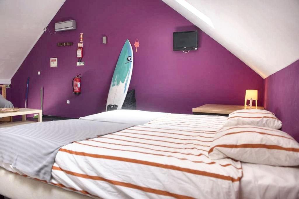 a bedroom with a bed and a surfboard on the wall at Cozy house in Peniche, 30 m² with sea view in Peniche