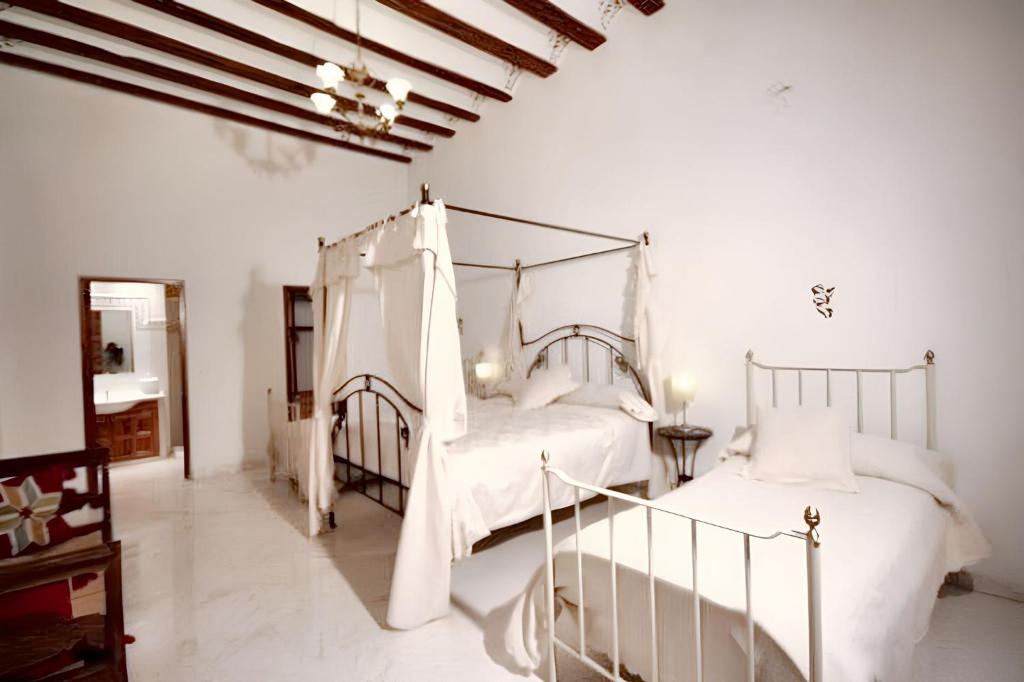 zwei Betten in einem Schlafzimmer mit weißen Wänden in der Unterkunft Charming House in Ayora + Terrace in Ayora