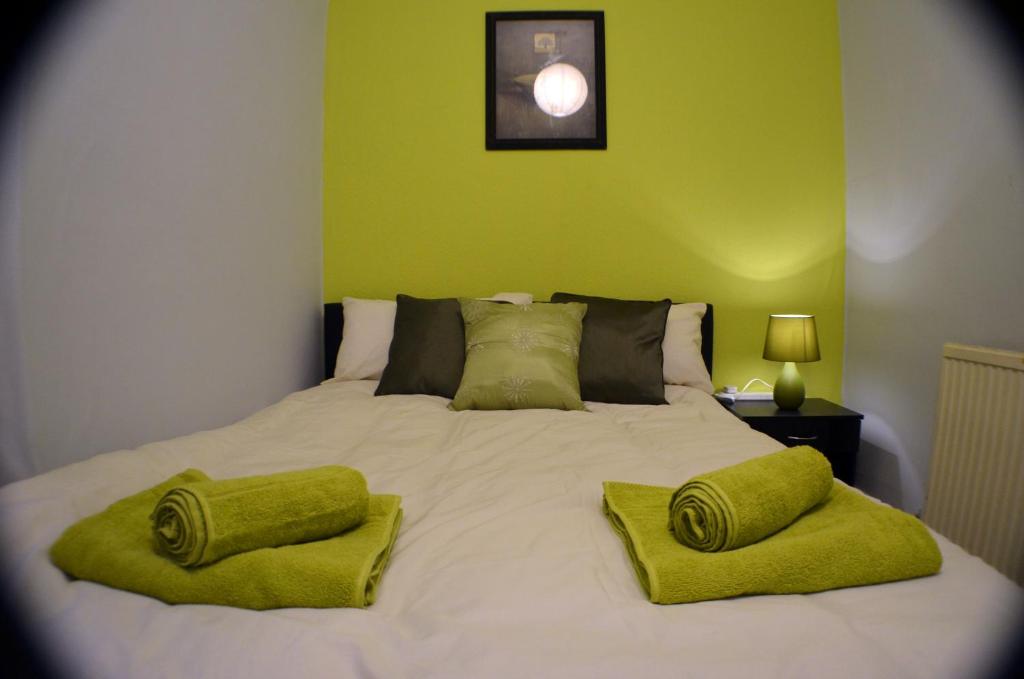 a bedroom with a large bed with green walls at Birchfields Guest House in Manchester