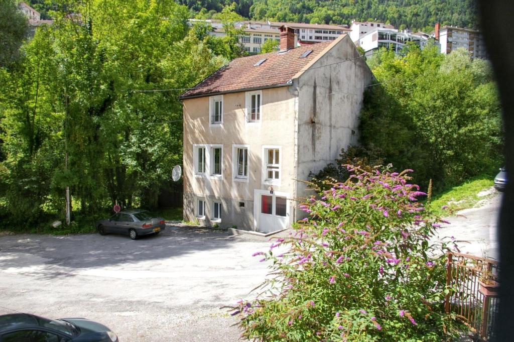 a house with a car parked in a parking lot at Maison familiale spacieuse à Saint-Claude, vue sur la rivière in Saint-Claude