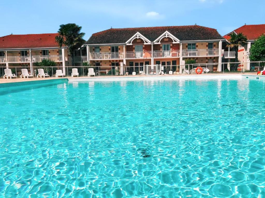 a large swimming pool in front of a resort at Appartement convivial Le Verdon 35 m² piscine partagée in Le Verdon-sur-Mer