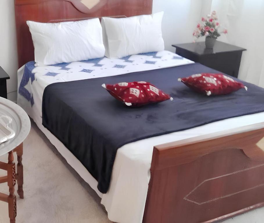 Un dormitorio con una cama con almohadas rojas. en Spacious apartment in Fez 70 m² with lovely garden, en Fez