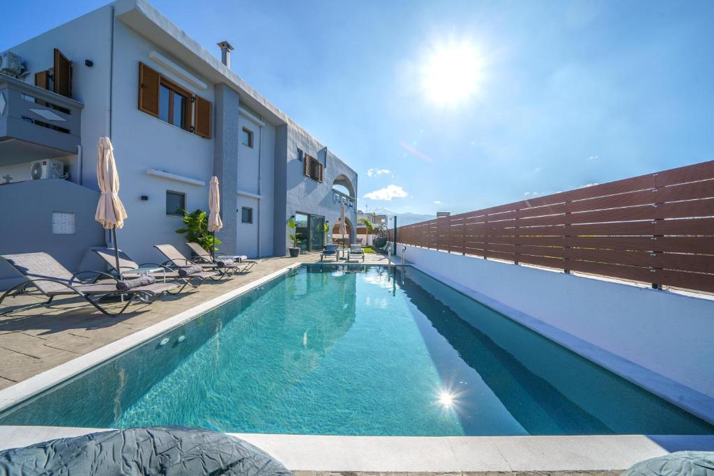a swimming pool with chairs next to a building at Vera Relaxo Villa, a Countryside Escape in Angeliana