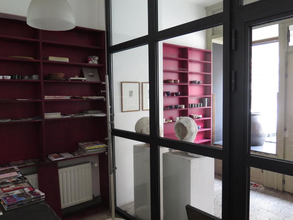 une chambre avec une fenêtre et une chambre avec des étagères roses dans l'établissement La Petite Lili, à Dinant