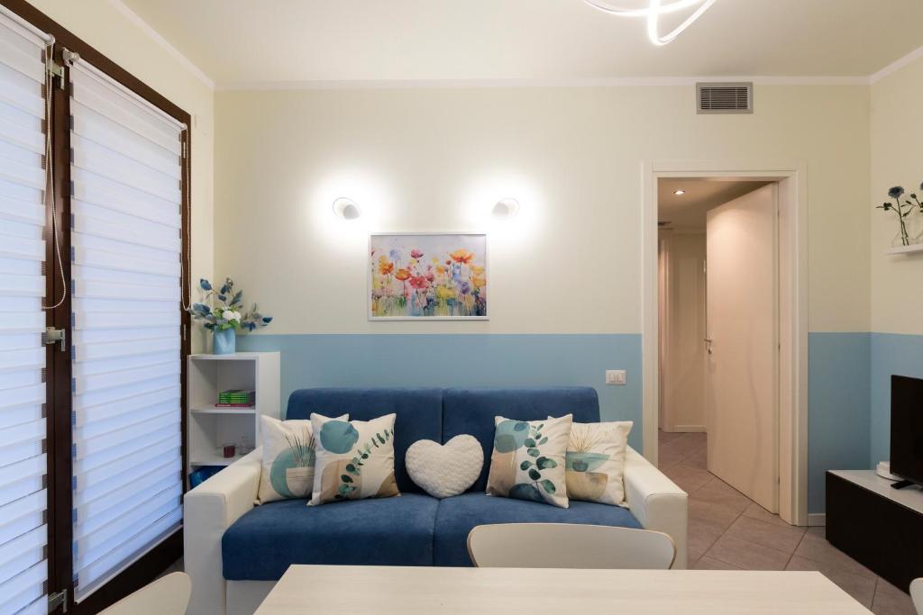 a living room with a blue couch with pillows at UniGarden - Bicocca District in Milan