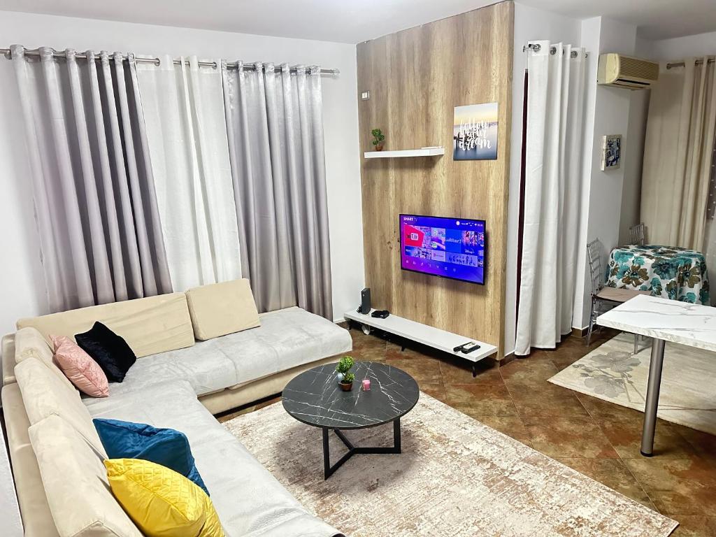 a living room with a couch and a tv at Dora apartment in Tirana