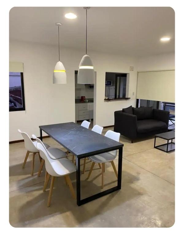 a living room with a black table and white chairs at Siloé Bella Vista in Bella Vista