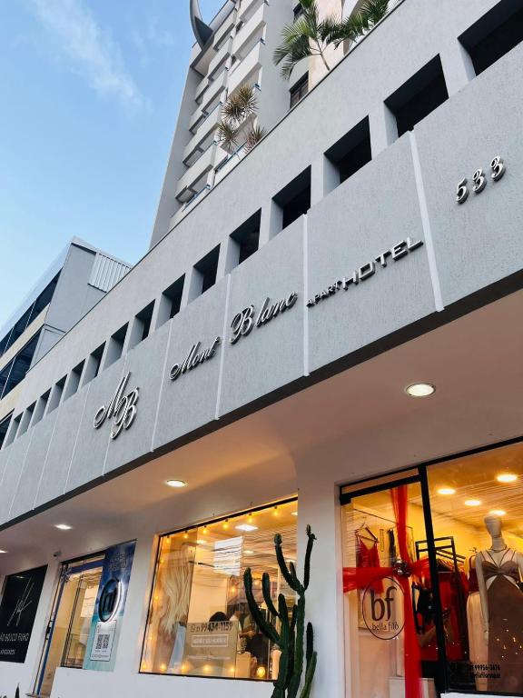 una tienda frente a un edificio con letreros en Mont Blanc Apart Hotel Nova Iguaçu, en Nova Iguaçu