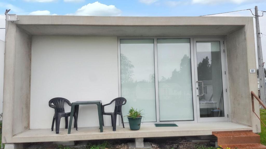 two chairs sitting on a porch next to a window at Charming Bungalow in Pataias with Shared Pool in Pataias
