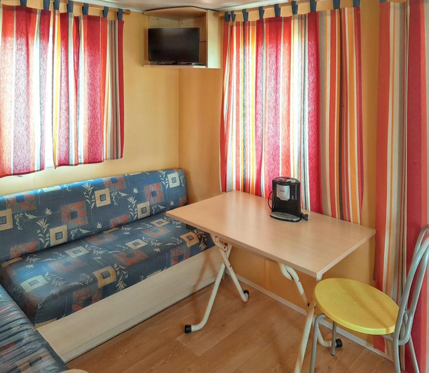 a small room with a table and a bench with a desk at Charming Bungalow in Pataias, 18 m² with Shared Pool. in Pataias
