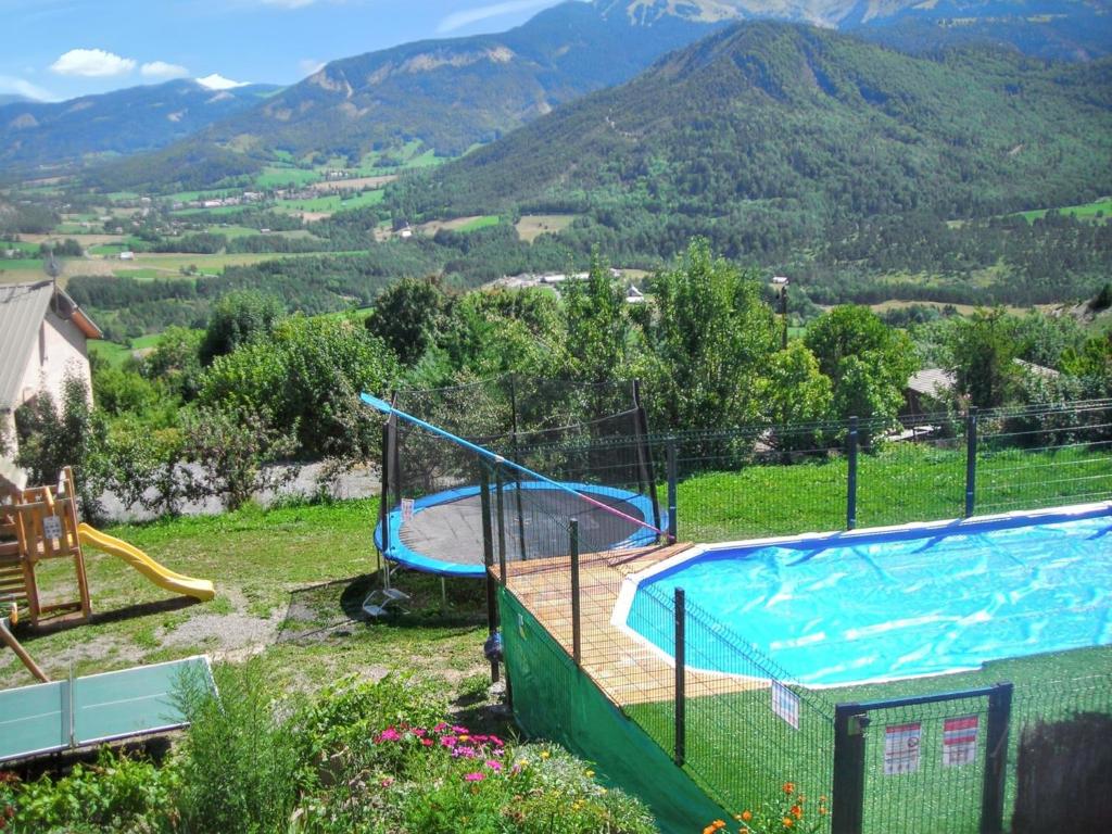 a swimming pool in a yard with mountains in the background at Appartement charmant à Selonnet avec piscine partagée et vue in Selonnet
