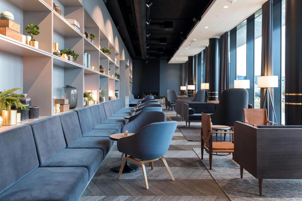 a waiting room with blue couches and tables at Clarion Hotel Air in Sola