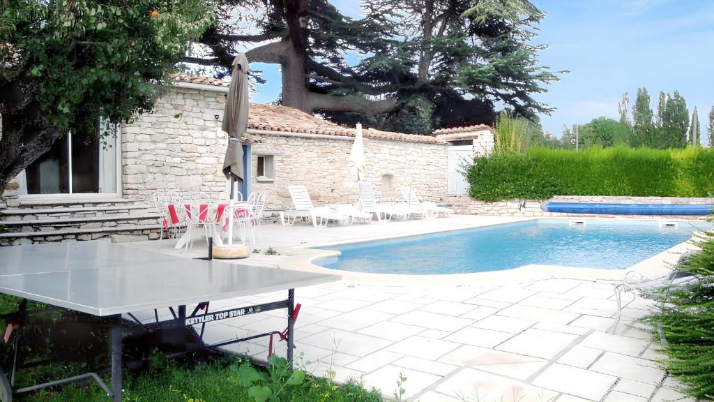 una piscina con una mesa junto a una casa en Villa charmante à Dauphin avec piscine privée, en Dauphin