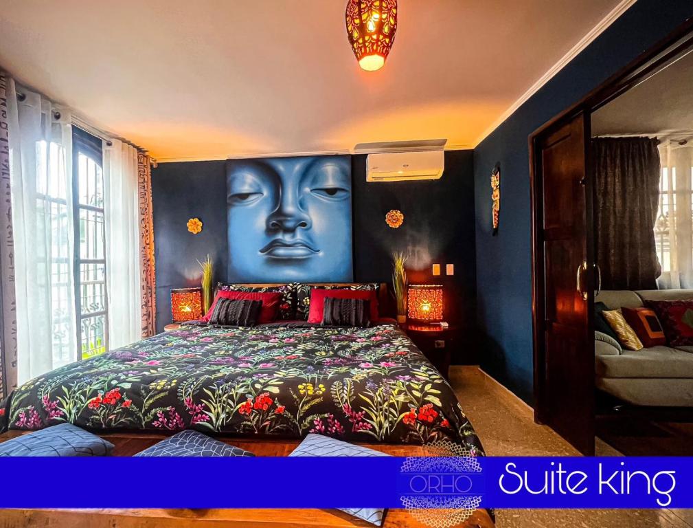 a bedroom with a bed with a face painted on the wall at ORHO HOTEL BOUTIQUE PANAMA Tocumen Airport free shuttle highway round trip 15 minuts in Tocumen