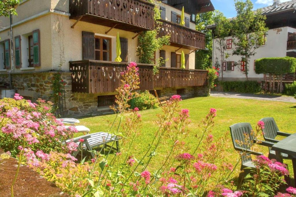 a garden with pink flowers and a house at Appartement confortable à Megève | 46m² | Vue sur montagne in Megève