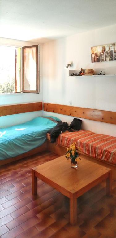 une chambre avec deux lits et une table dans l'établissement Appartement élégant à Grosseto-Prugna de 46 m² avec piscine partagée, à Grosseto-Prugna