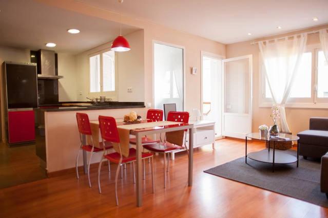 sala de estar con mesa y sillas rojas en Apartamento Alameda, en Valencia