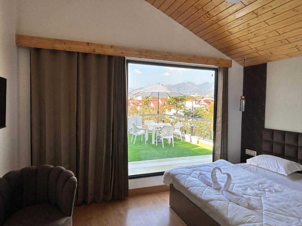 a bedroom with a bed and a large window at Aliaras Homestay in Dehradun